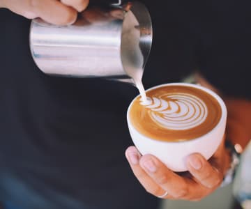 barista is doing a picture in cup of coffee
