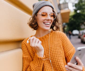 smiling woman with a phone on street